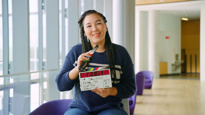 A Kellogg student holding a clapperboard